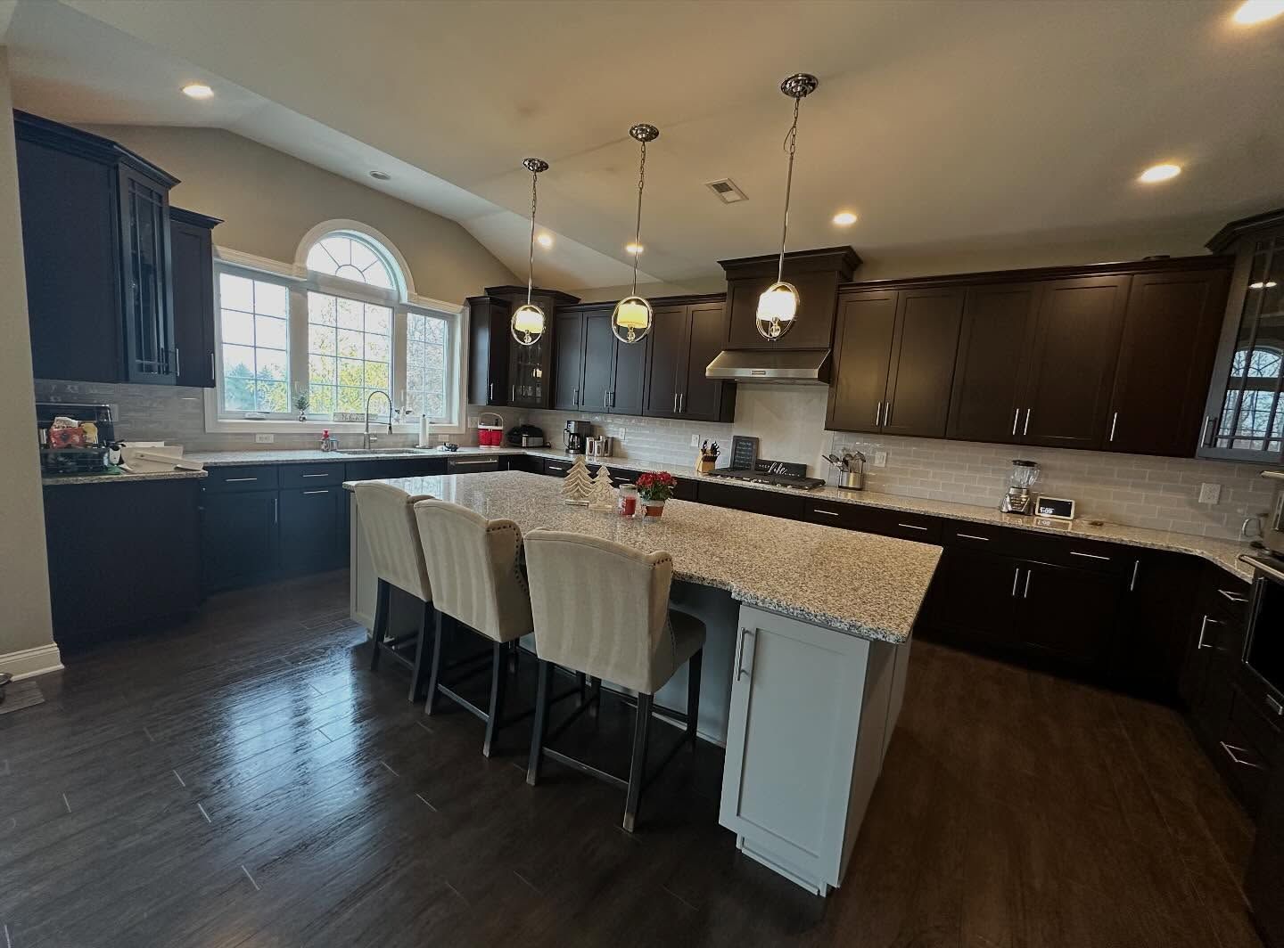 Spotless kitchen with dark cabinetry cleaned by Trinal Cleaning Services